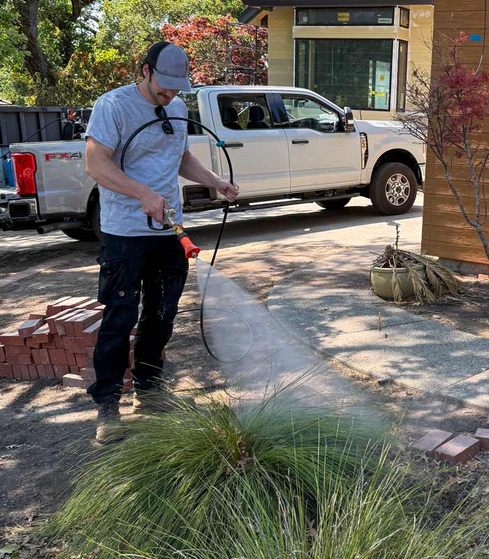 Man spraying Komodo Fire Suppressant on plants